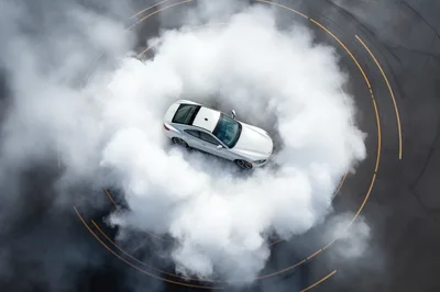 White Sports Car Performing A Drift Maneuver