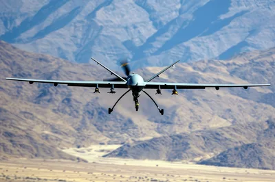 MQ-9 Reaper Drone Flying Over Desert Mountains