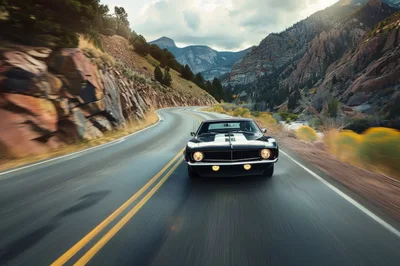 Classic Black Muscle Car Driving Through Mountain Canyon