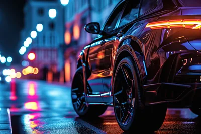 Luxury SUV Parked on Wet City Street at Night