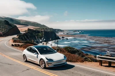 White Tesla Model 3 Driving Along Pacific Coast Highway