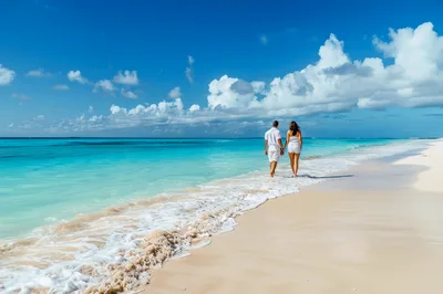 Couple Walking Hand In Hand On Tropical Beach