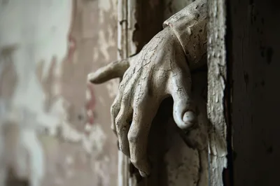 Cracked Antique Statue Hand Reaching From Doorway