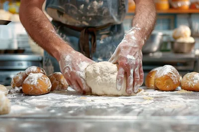 Professional Baker Kneading Fresh Dough In A Bakery