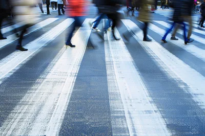 Blurred Pedestrians Crossing A Busy City Street