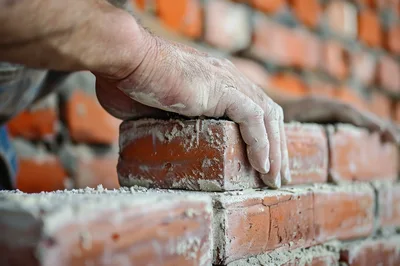 Construction Worker Laying Red Clay Bricks