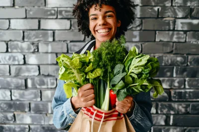 Young Woman Holding A Bag Of Fresh Vegetables