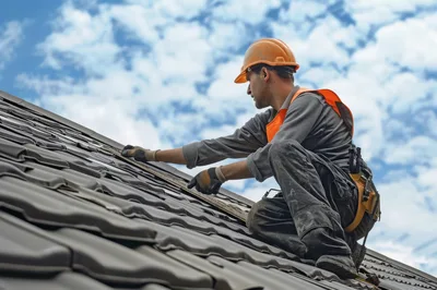 Construction Worker Installing Roof Tiles On Residential House