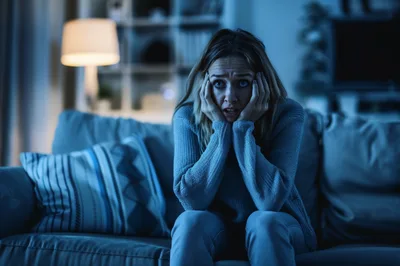 Scared Woman Watching A Horror Movie At Home