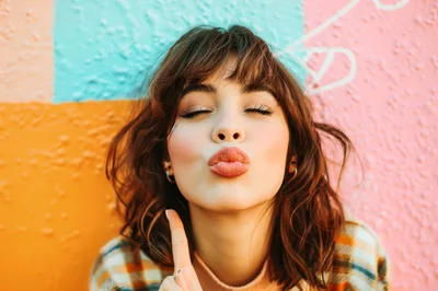 Young Woman Posing With A Playful Kissing Expression
