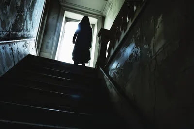 Silhouette Of A Mysterious Figure Standing On Dark Stairs