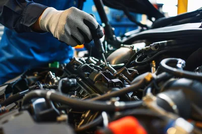 Mechanic Using Screwdriver On Car Engine