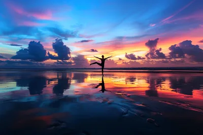 Woman Practicing Yoga Pose On Beach At Sunset