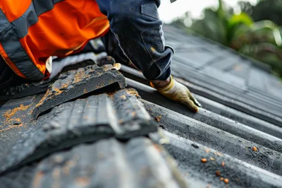 Construction Worker Repairing Roof Tiles