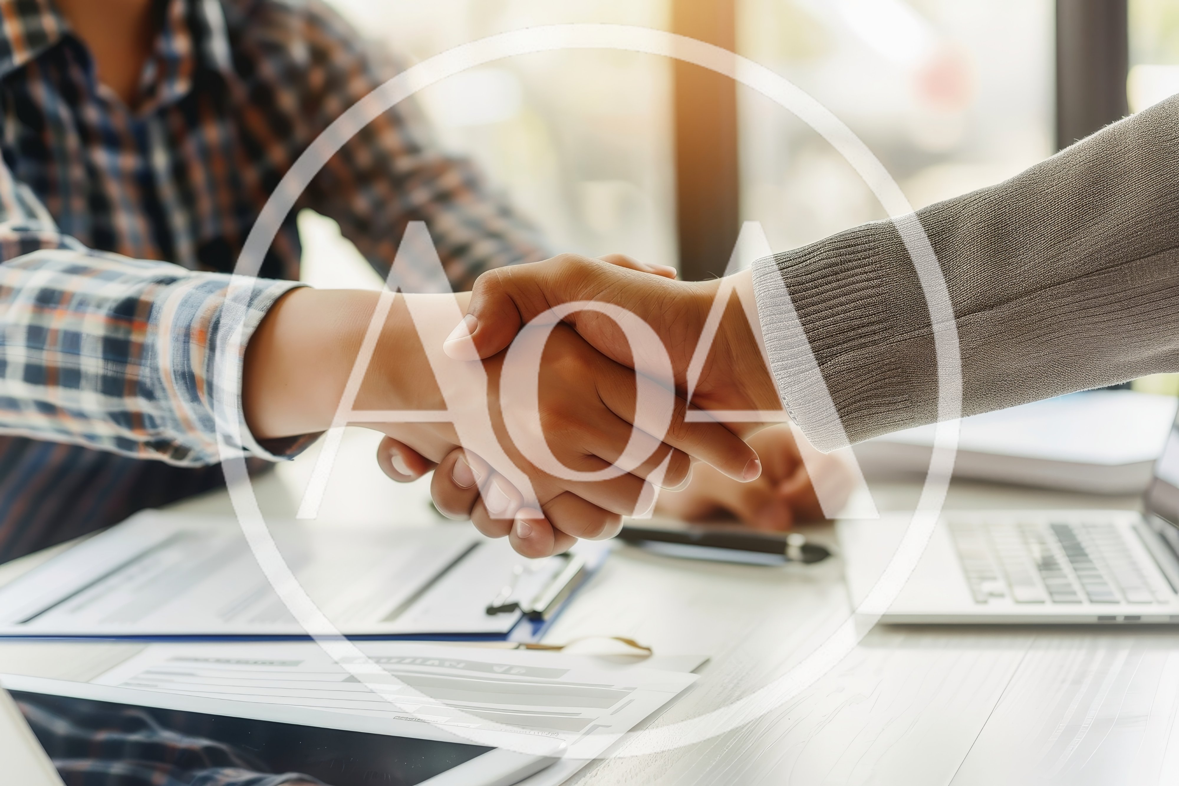 Business Professionals Shaking Hands Over Office Desk