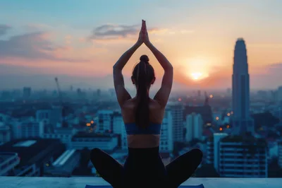 Woman Practicing Yoga On Rooftop At Sunset