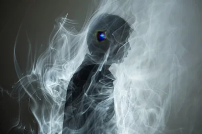 Silhouette Of A Person Surrounded By Swirling Smoke