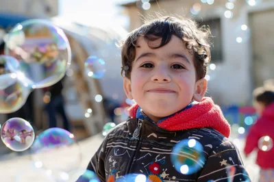 Happy Young Boy Playing With Bubbles Outdoors
