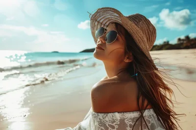 Young Woman Wearing Straw Hat And Sunglasses On Beach