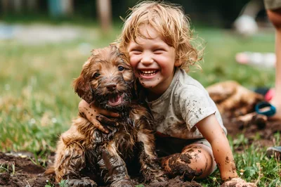Happy Child Hugging Muddy Puppy Outdoors