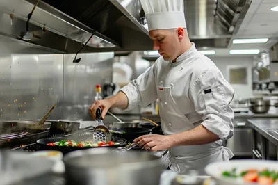 Professional Chef Cooking Vegetables In A Commercial Kitchen