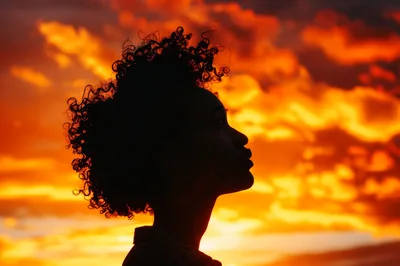 Silhouette Of A Woman With Curly Hair At Sunset