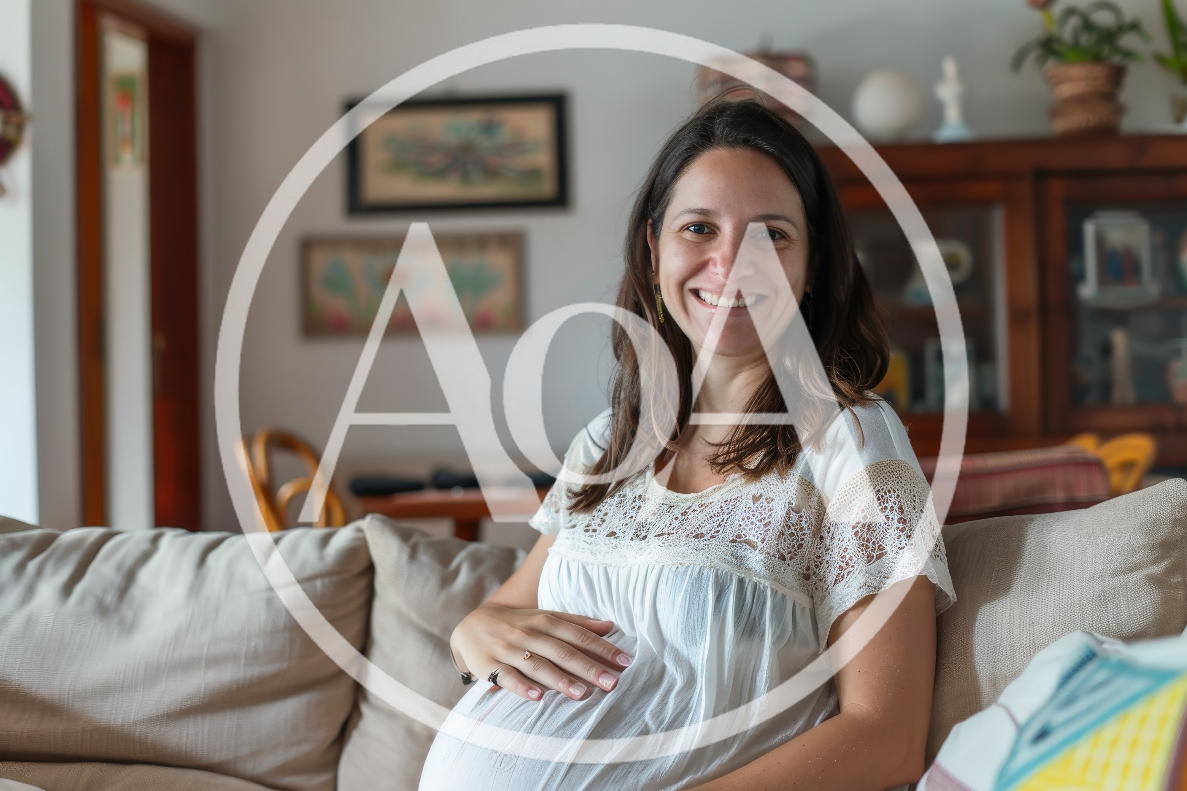Pregnant Woman Smiling While Sitting On A Sofa