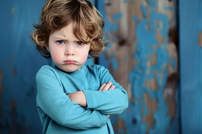 Portrait Of A Grumpy Toddler With Crossed Arms