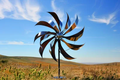 Kinetic Metal Wind Spinner Sculpture In A Grassy Field