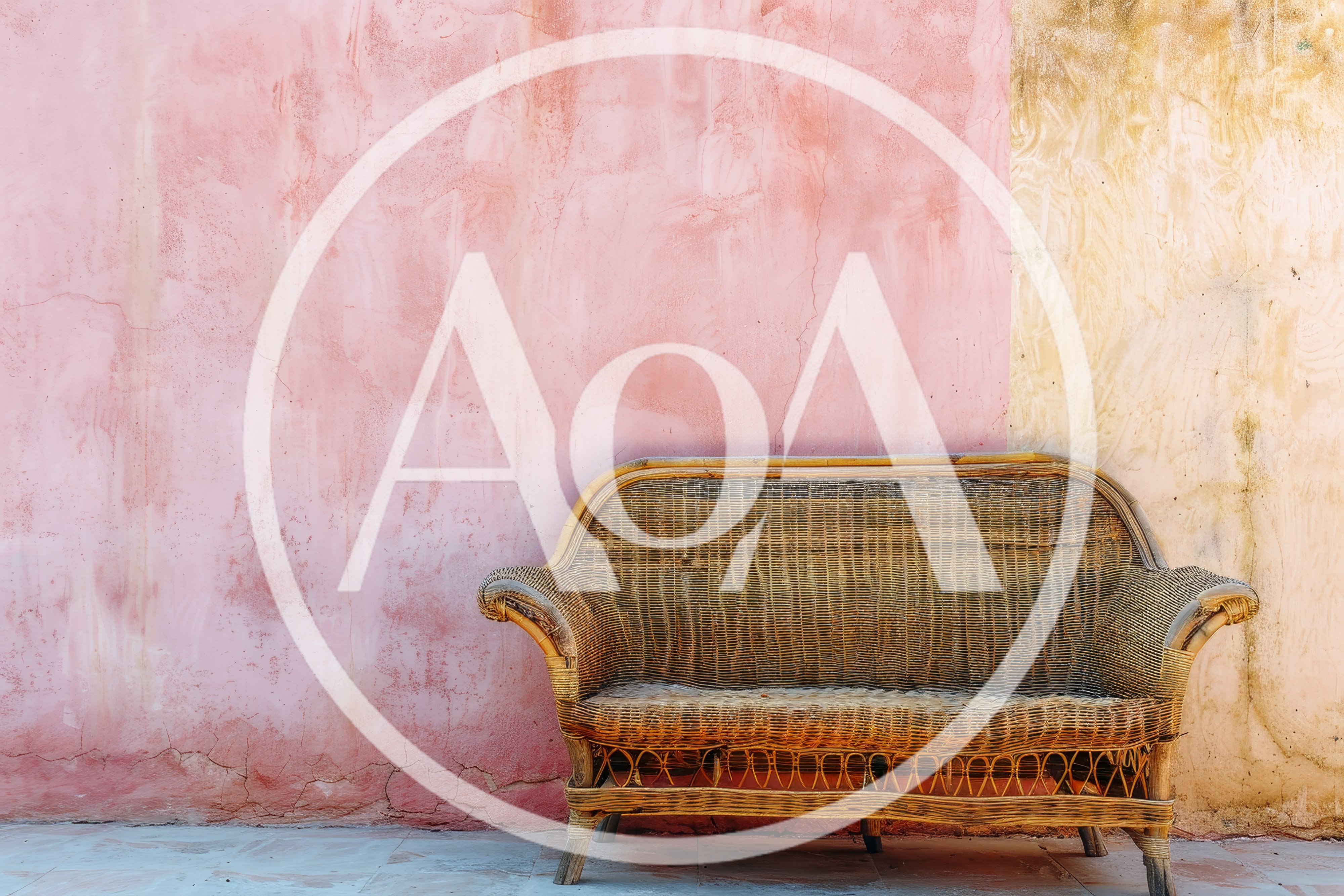 Wicker Sofa Against A Two Tone Pink And Beige Wall