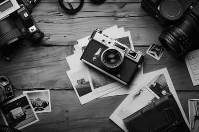 Vintage Film Cameras And Photographs On Wooden Table