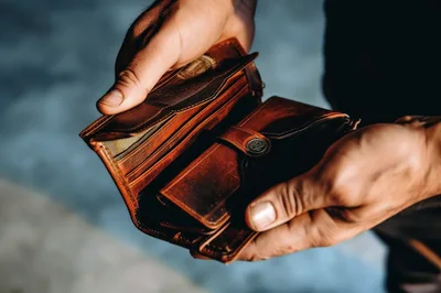 Person Holding An Open Brown Leather Wallet