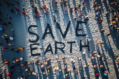Aerial View Of People Forming Save Earth Text On Beach
