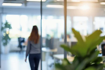 Businesswoman Walking Through Modern Open Plan Office