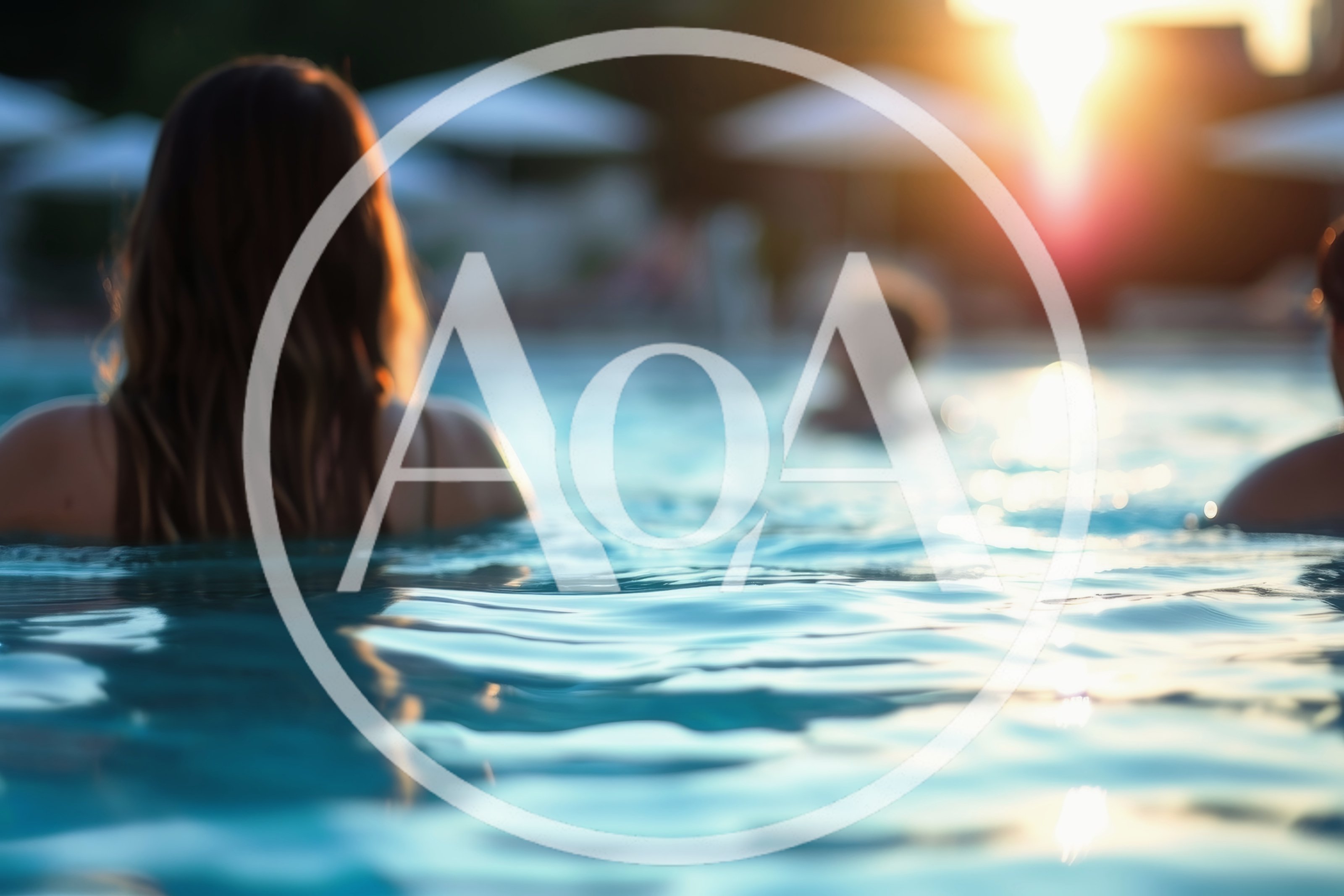 People Relaxing In A Swimming Pool At Sunset