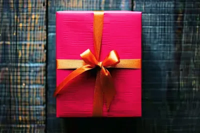 Pink Gift Box With Orange Ribbon On Wooden Background