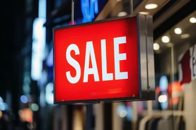 Illuminated Red Sale Sign Hanging Outside Retail Store
