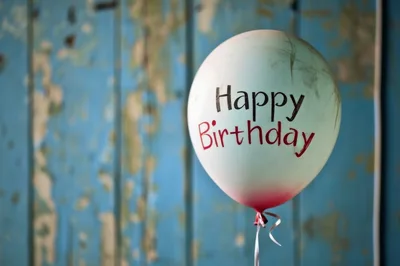 Single Dirty Happy Birthday Balloon Against Weathered Blue Wood