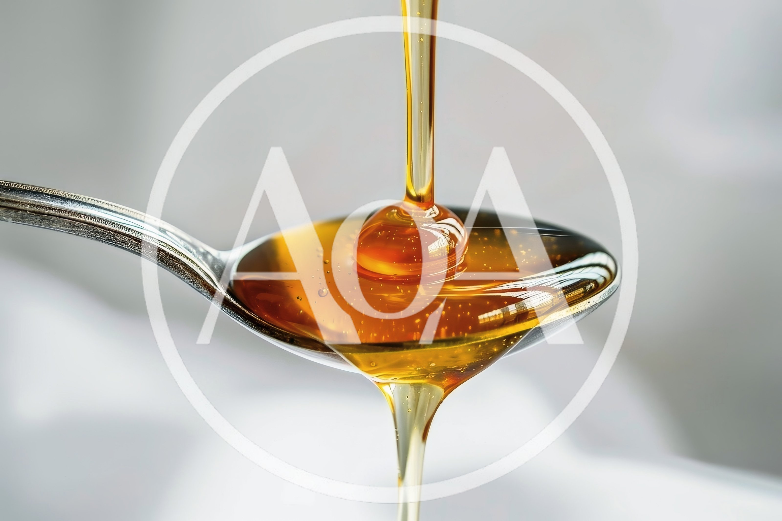 Golden Honey Pouring Onto A Silver Spoon