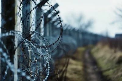 Barbed Wire Fence Along A Remote Dirt Path