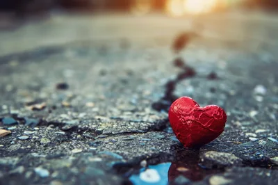 Red Heart Shaped Candy On Cracked Asphalt