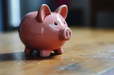 Pink Ceramic Piggy Bank On Wooden Table