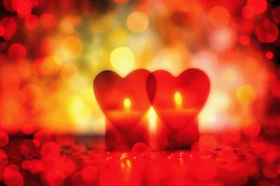 Two Heart Shaped Candles Glowing With Bokeh Background