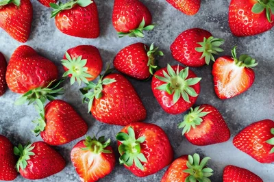 Fresh Ripe Strawberries Scattered on Gray Surface