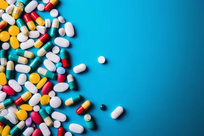 Assorted Pharmaceutical Pills and Capsules on Blue Background
