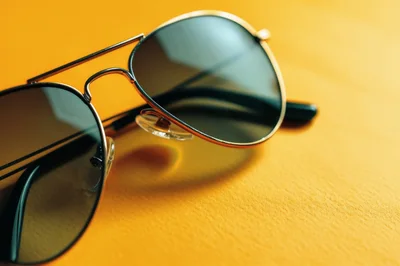 Aviator Sunglasses Resting On A Vibrant Yellow Surface