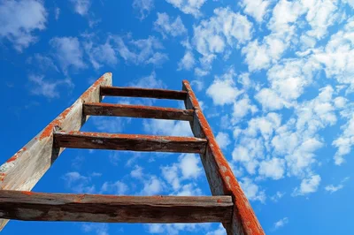 Old Wooden Ladder Reaching Toward Blue Sky