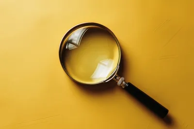 Magnifying Glass Resting On A Solid Yellow Background