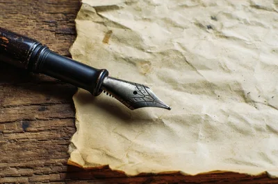 Fountain Pen Resting On Aged Parchment Paper