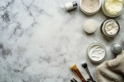 Skincare Products and Makeup Brushes on Marble Surface